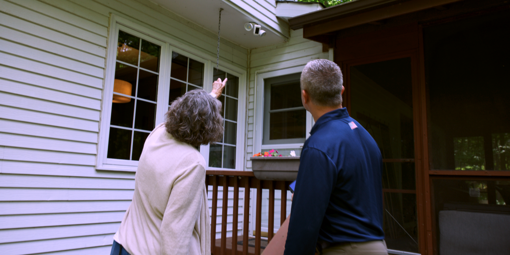 Homeowner pointing out repairs to a Jeff Buys Your House home buying specialist while discussing the sale of a fixer-upper.
