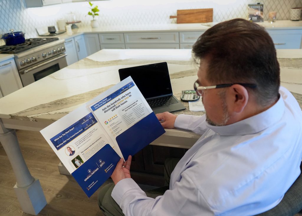 Homeowner reviewing information about home selling options before foreclosure