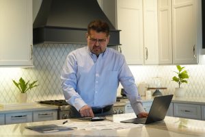 Homeowner reviewing bills and finances while considering options before foreclosure